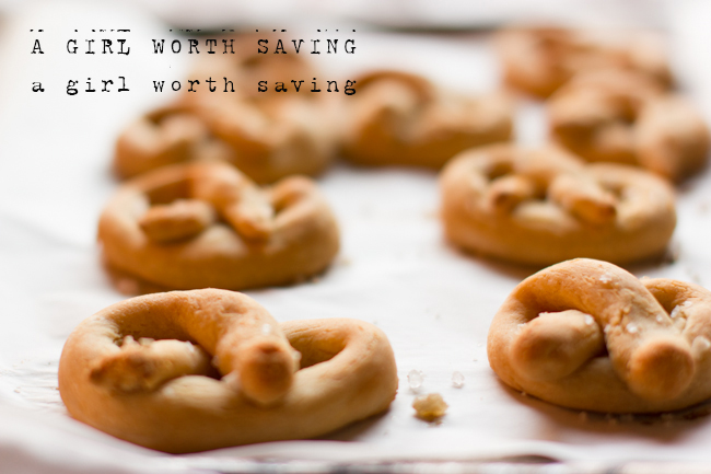 soft gluten free pretzels on a baking sheet with salt sprinkled on top. 