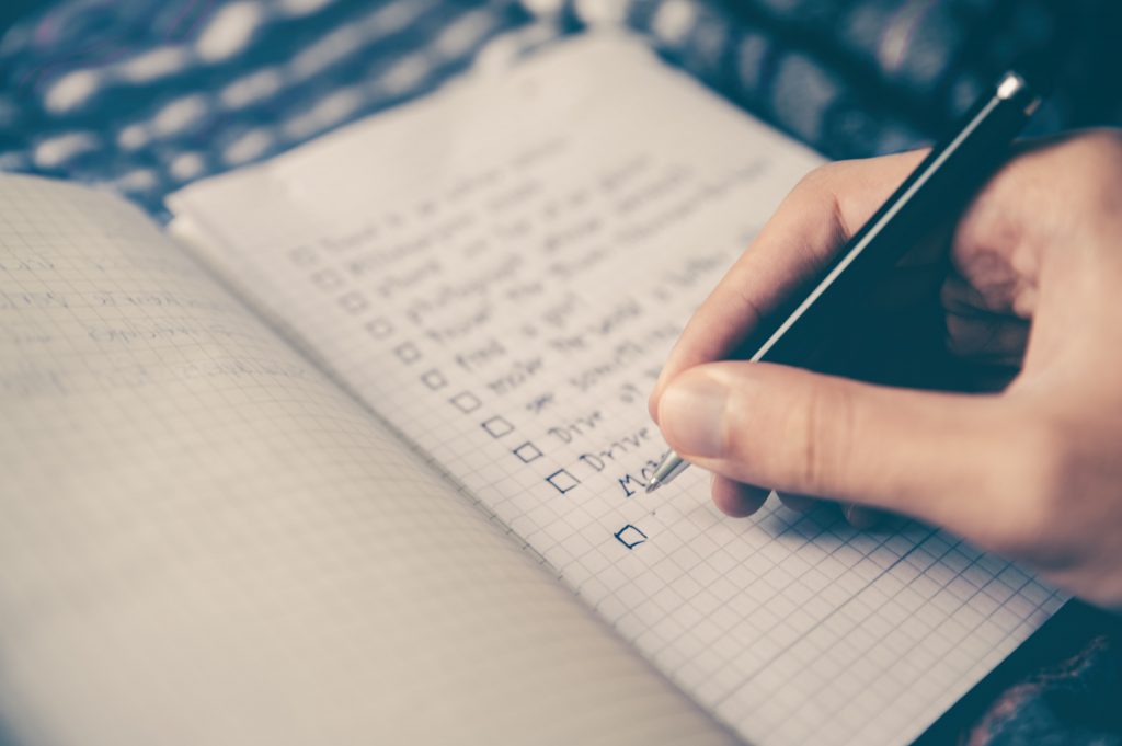 a person writing out a depression self care checklist 