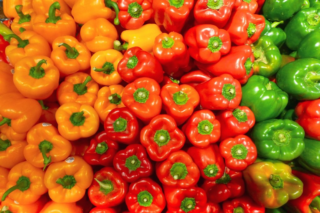 red, orange and green bell peppers before storage