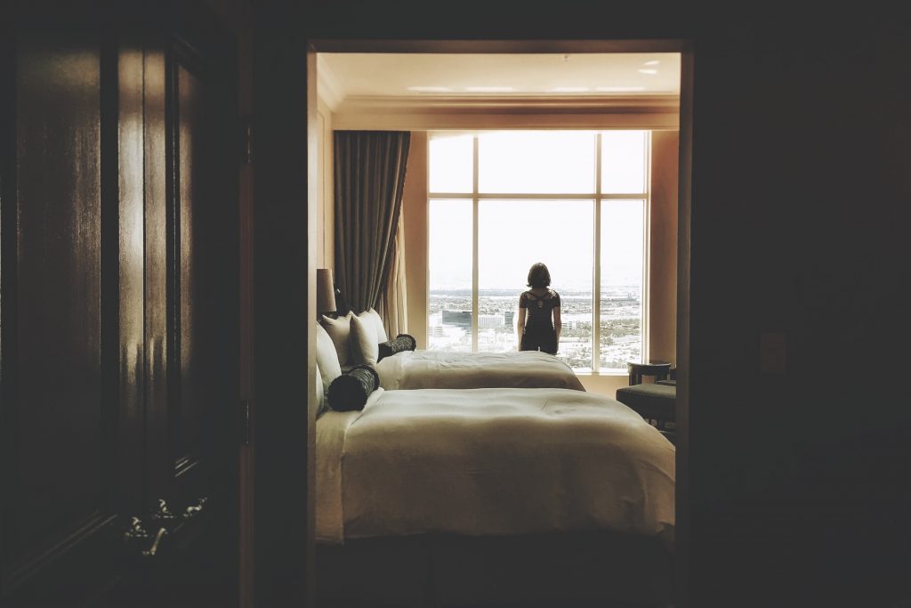 woman staring out the window of a hotel room