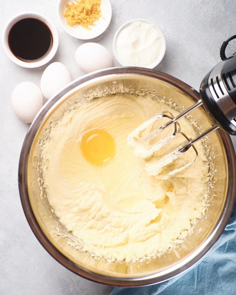 Mixing eggs into the batter with a hand mixer