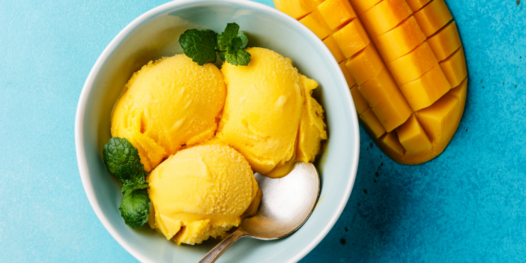 mango ice cream made with condensed milk in a bowl with mint leaves 