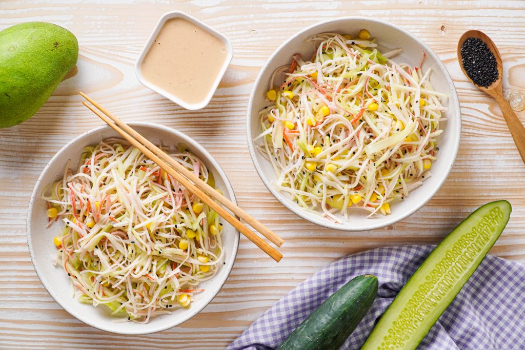 Two bowls of dry kani salad in bowls with spicy mayo sauce on the side 