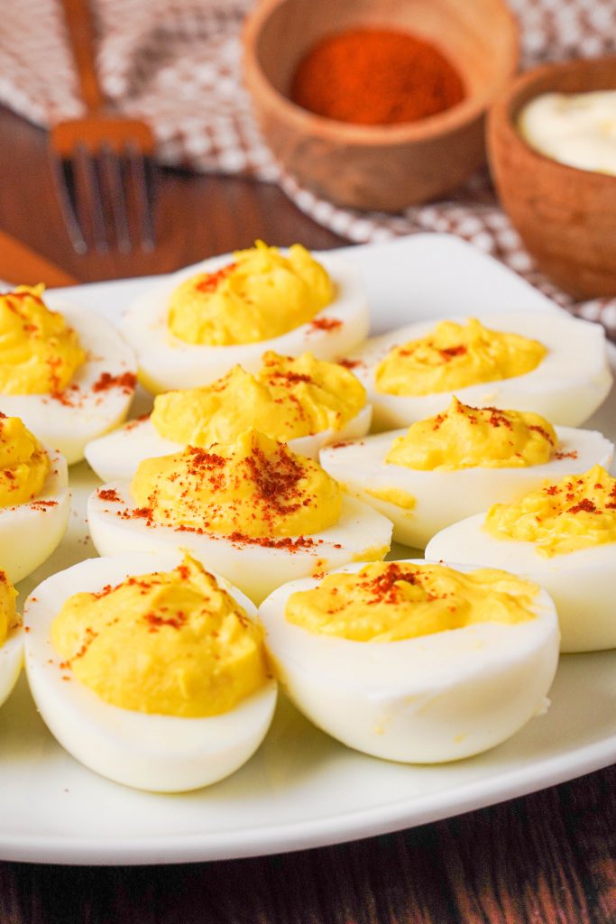 Close up of a plate of keto deviled eggs with spices in the background 