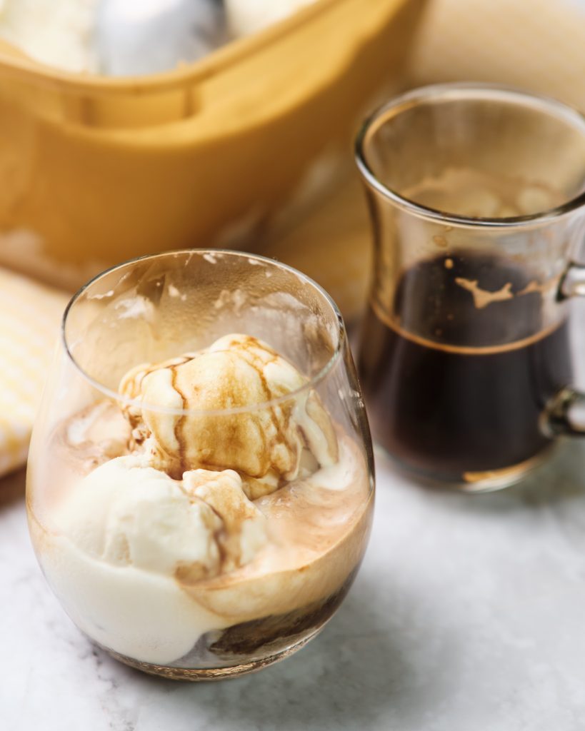 Close up of affogato drink with coffee and ice cream in the background 