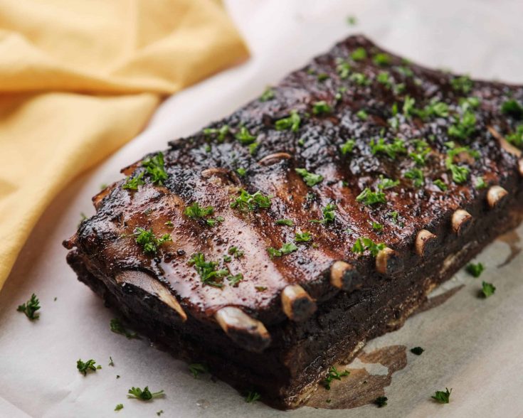 spork spare ribs on a piece of butcher block paper with herbs on top