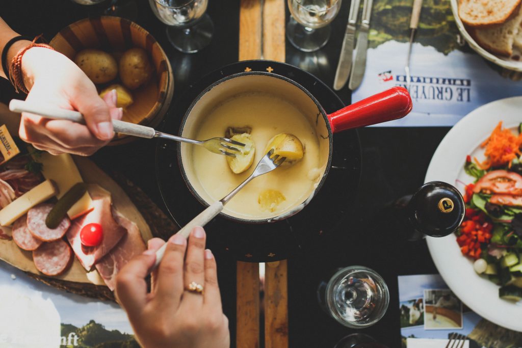dipping cooked potatoes in a fondue pot 