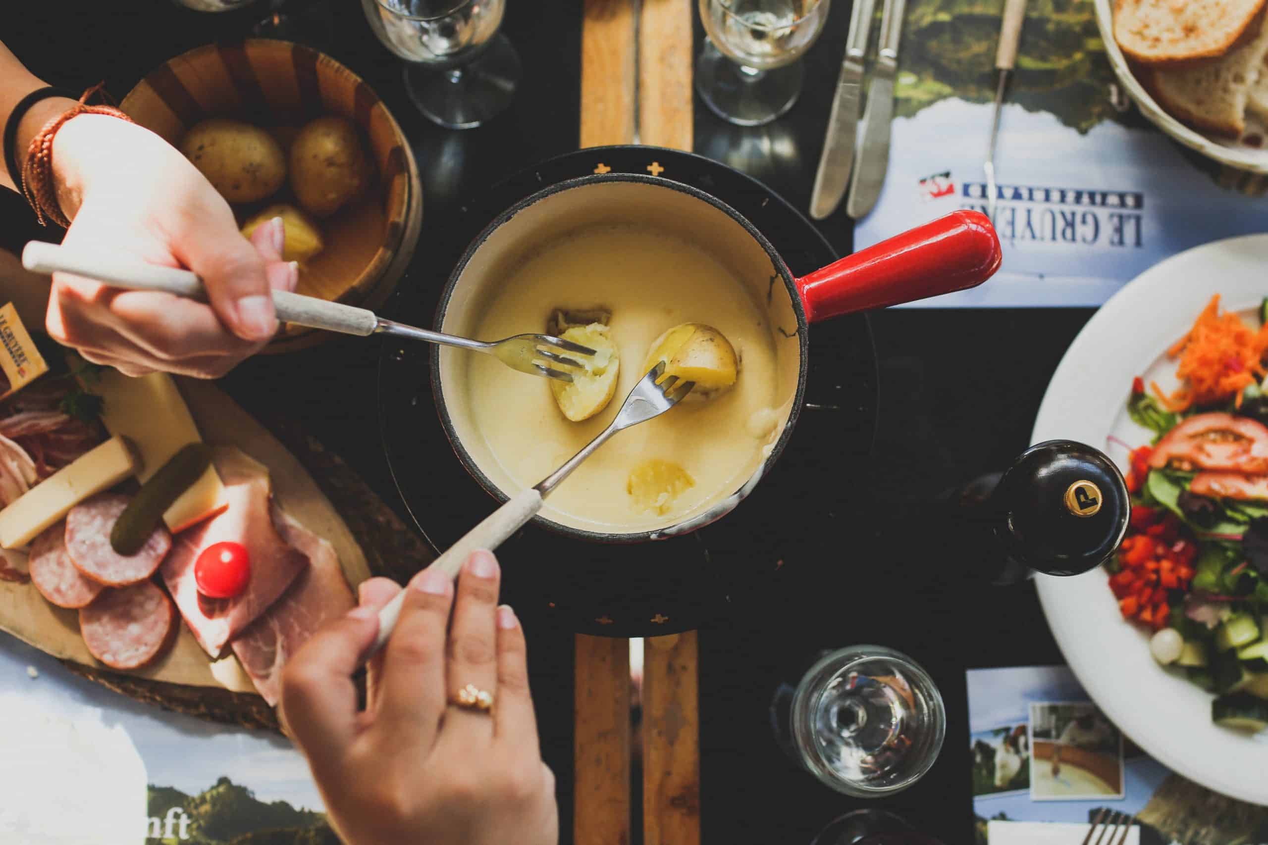 dipping small potatoes in a fondue pot