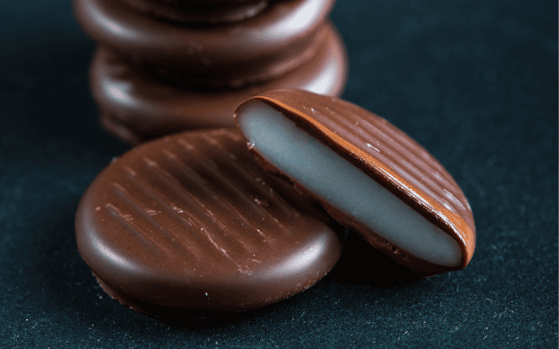Close-up photo: Peppermint patties showcased on a black wooden surface.