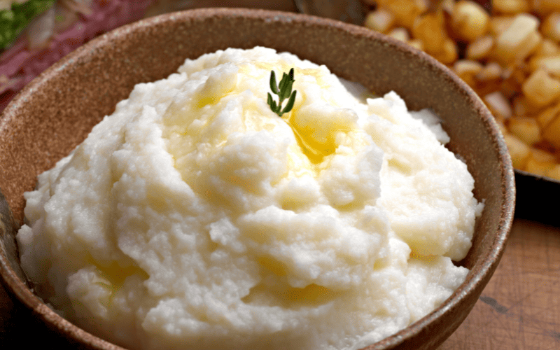 close up of mashed potatoes in a bowl with melted button on top