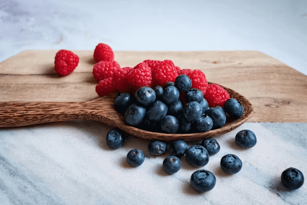 5 Superfoods To Optimize any Salad Kelly Bejelly Wooden spoon with blueberries and raspberries for salad