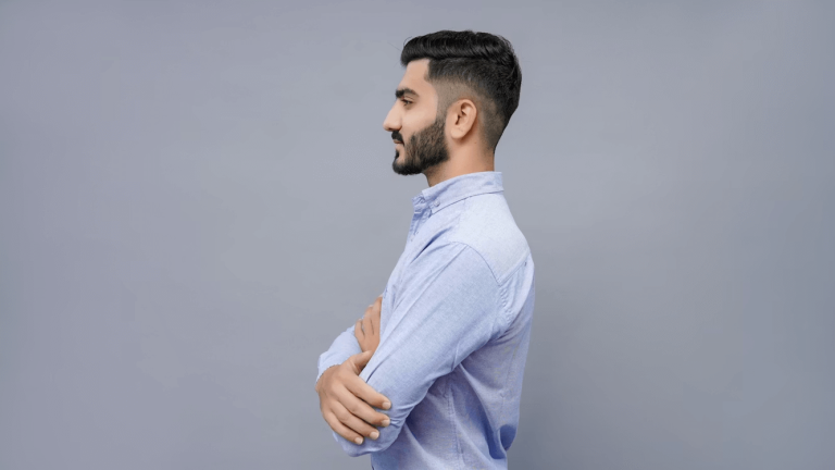 A bearded man in a blue shirt discussing beard hair loss treatments