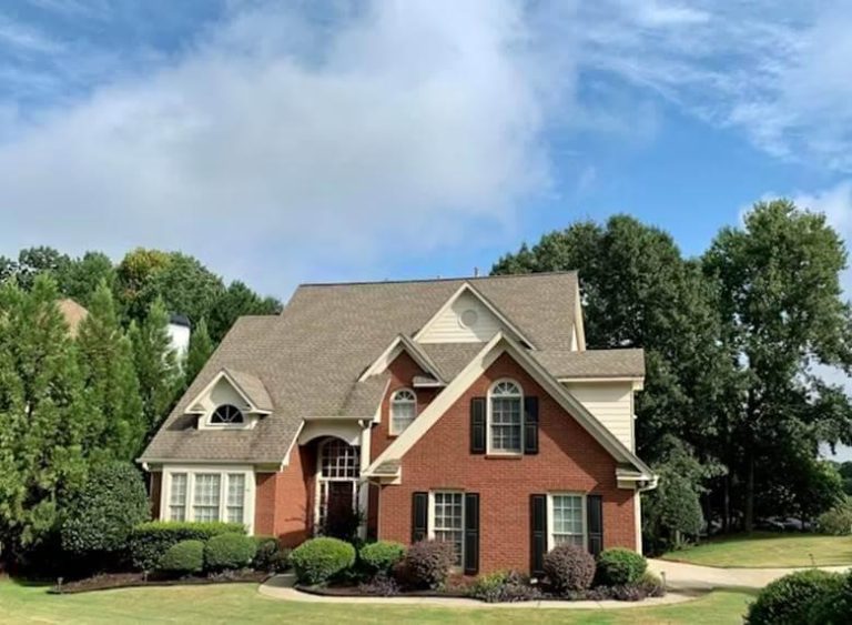 A red brick house with a spacious front yard