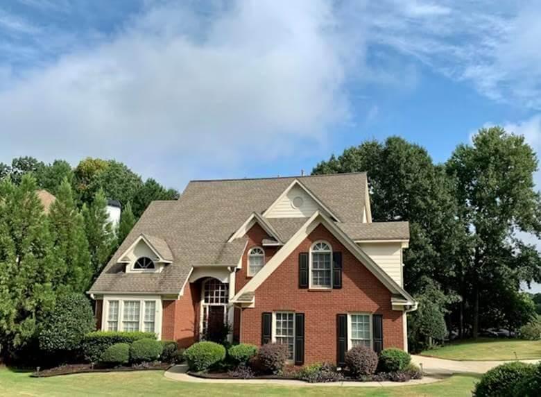 A red brick house with a spacious front yard