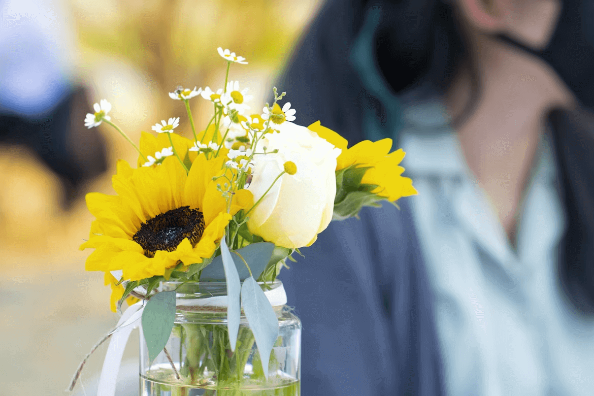 A vase of yellow and white flowers for home decor