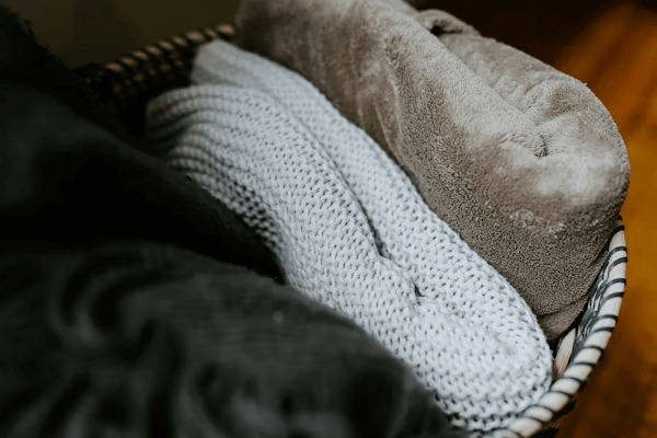 Basket with blankets on wooden floor