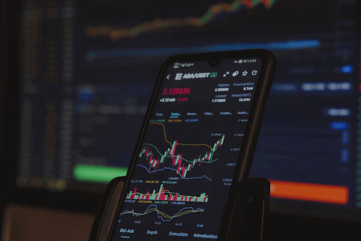 Cell phone showing crypto stock market data for beginner investors