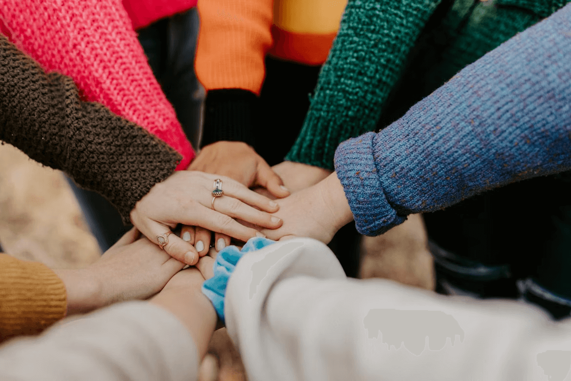 People holding hands in a circle for stress relief