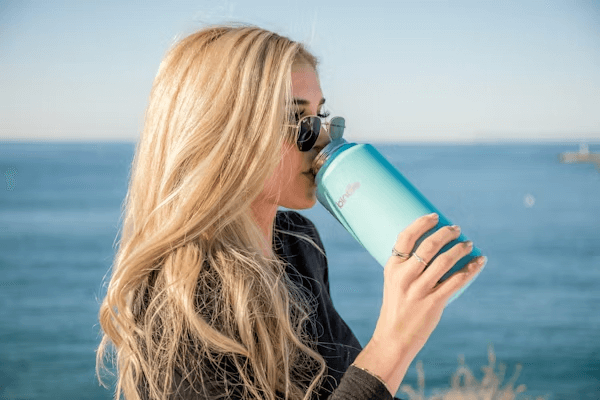 Pregnant woman staying hydrated with blue water bottle