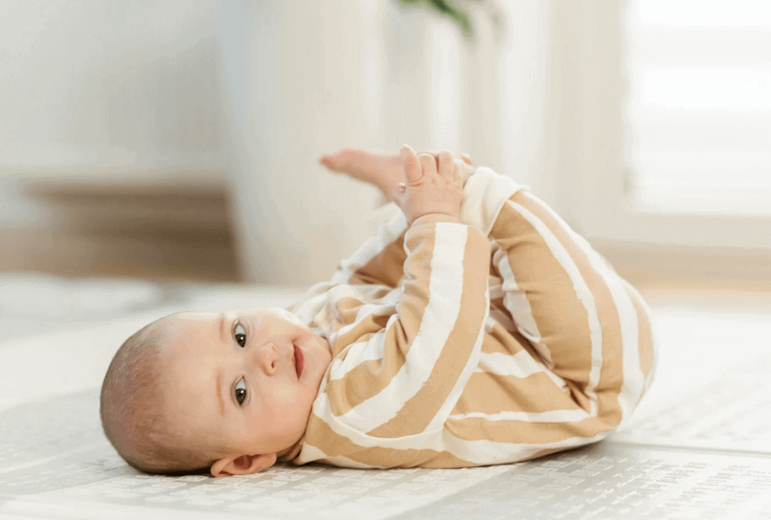 Baby lying on its back on the floor at 3 months old