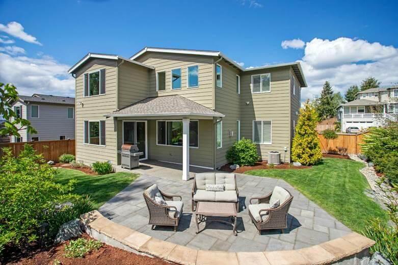 Patio with table and chairs in a low-maintenance backyard.