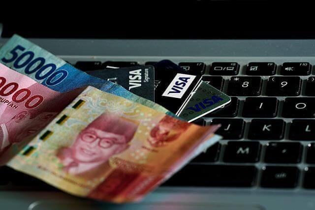 Money on a laptop keyboard, symbolizing financial decisions for