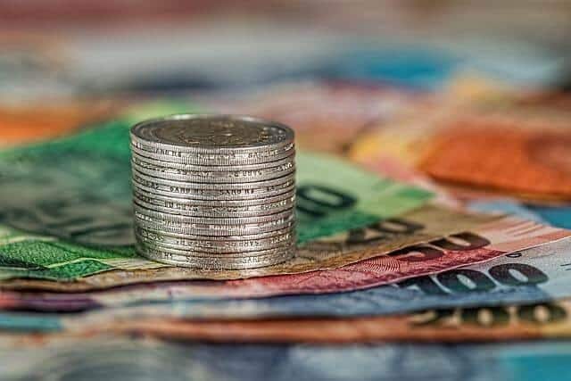 How to Reduce Financial Distractions While Focusing on Debt Goals Kelly Bejelly Stack of coins on a pile of money