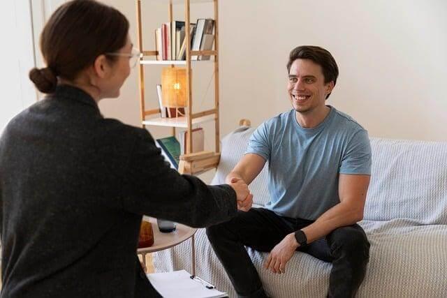 Woman and man shaking hands on a couch