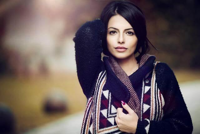 Woman in a stylish sweater with her hand on
