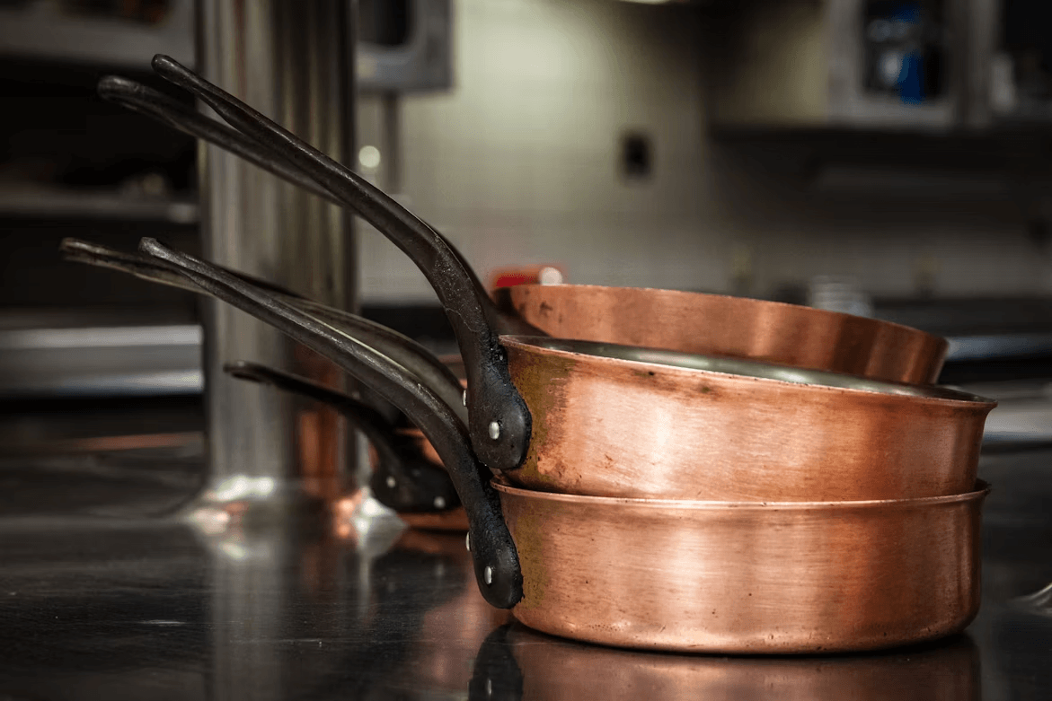 A pair of copper pots on a counter