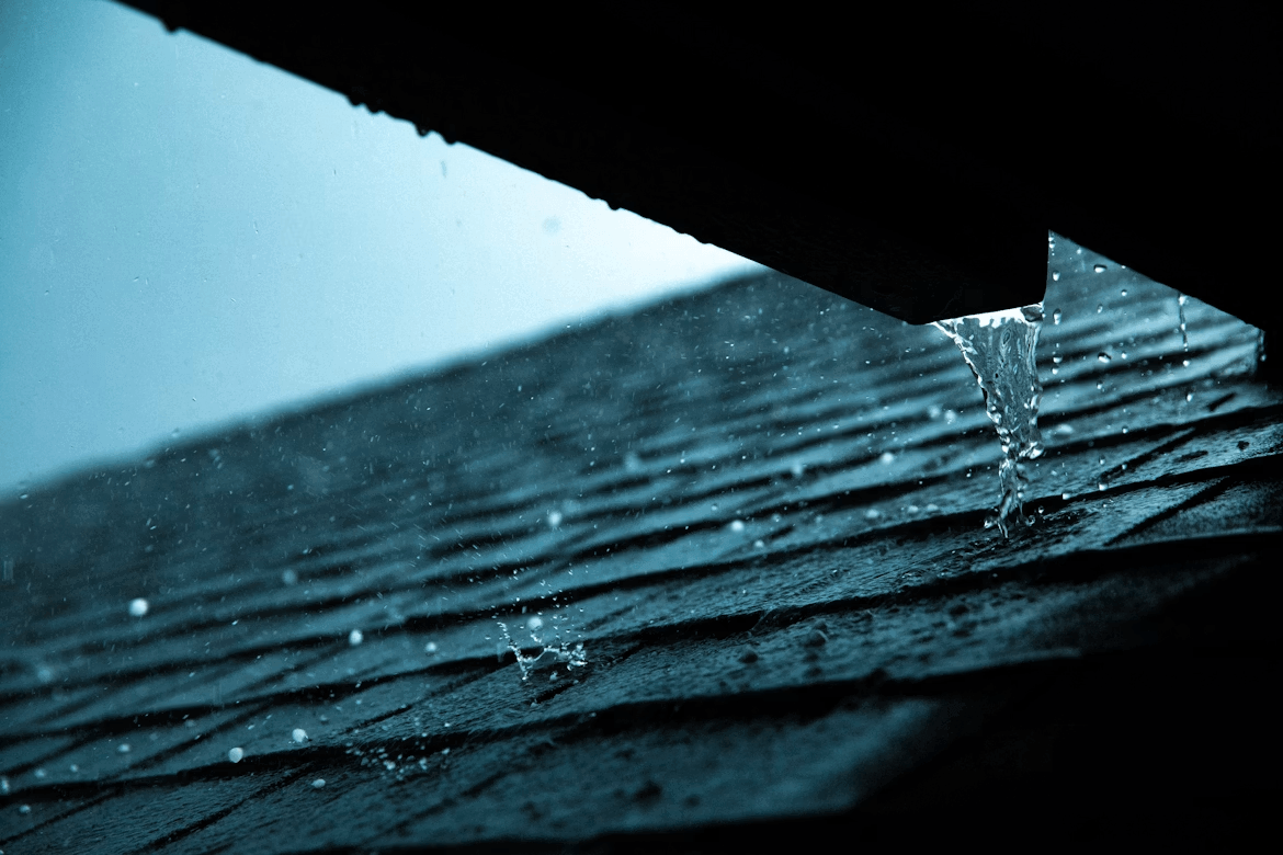 Close-up of a damaged roof with water