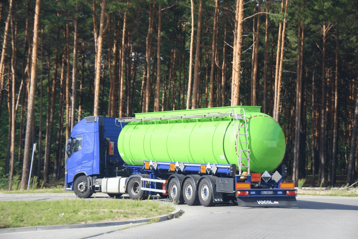 Large green tanker truck driving on a
