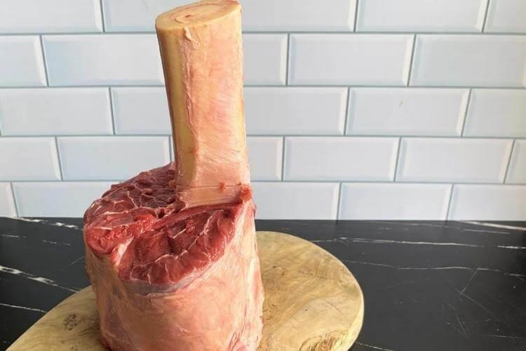 Large organic beef cut on a wooden cutting board