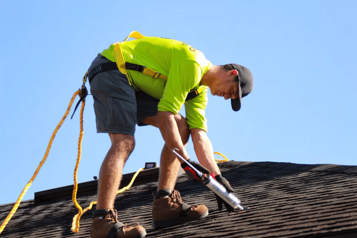 Man working on a roof with tools inspecting for new