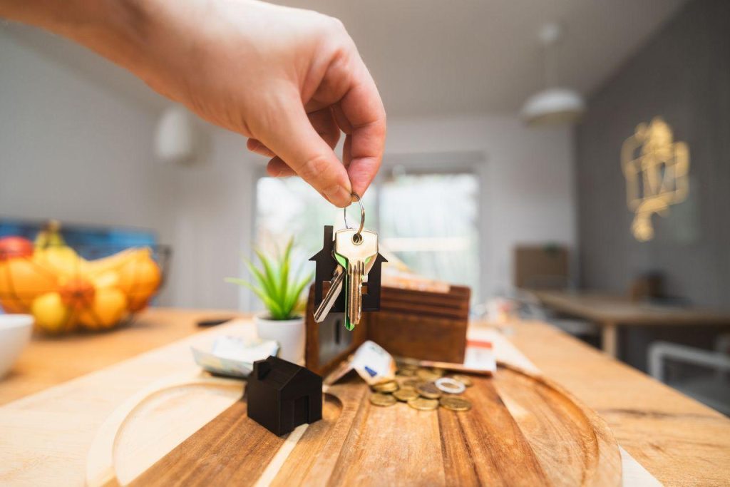 person holding a house key, symbolizing homeownership and