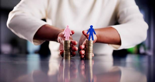 Person stacking coins next to man and woman figurines,