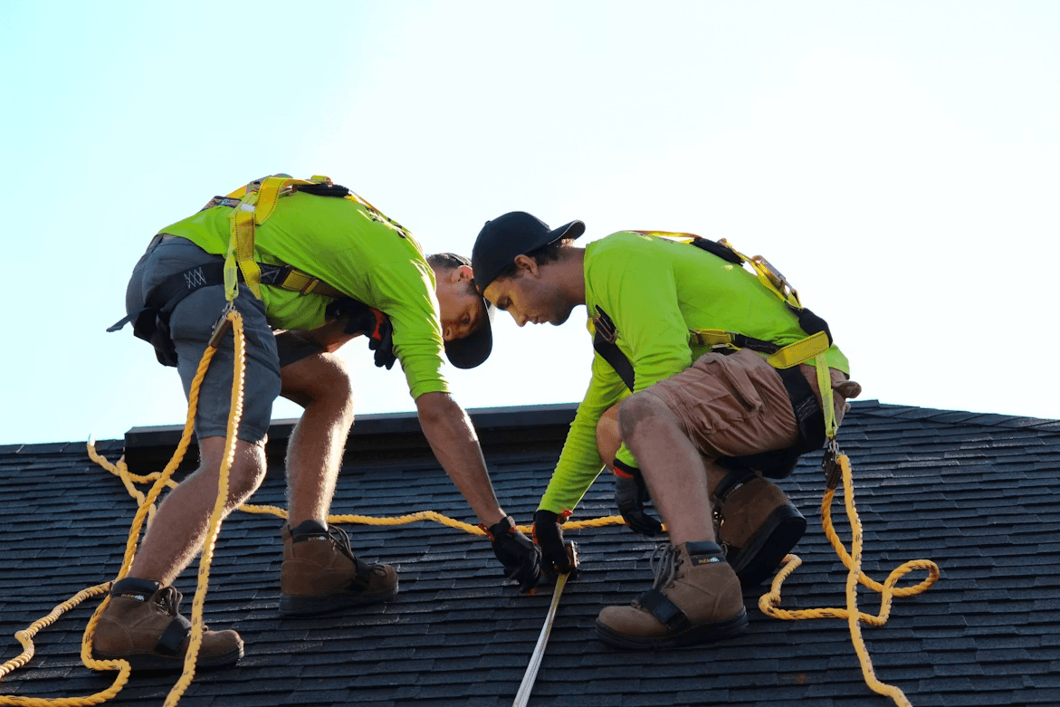 Two men working on a roof, ready for replacement