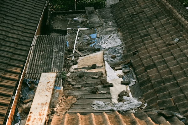 View of an old house roof being inspected for