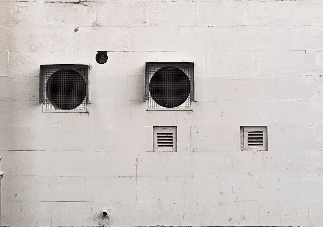 What Are the Warning Signs of Mold in Your HVAC System? Kelly Bejelly White wall with three round HVAC vents