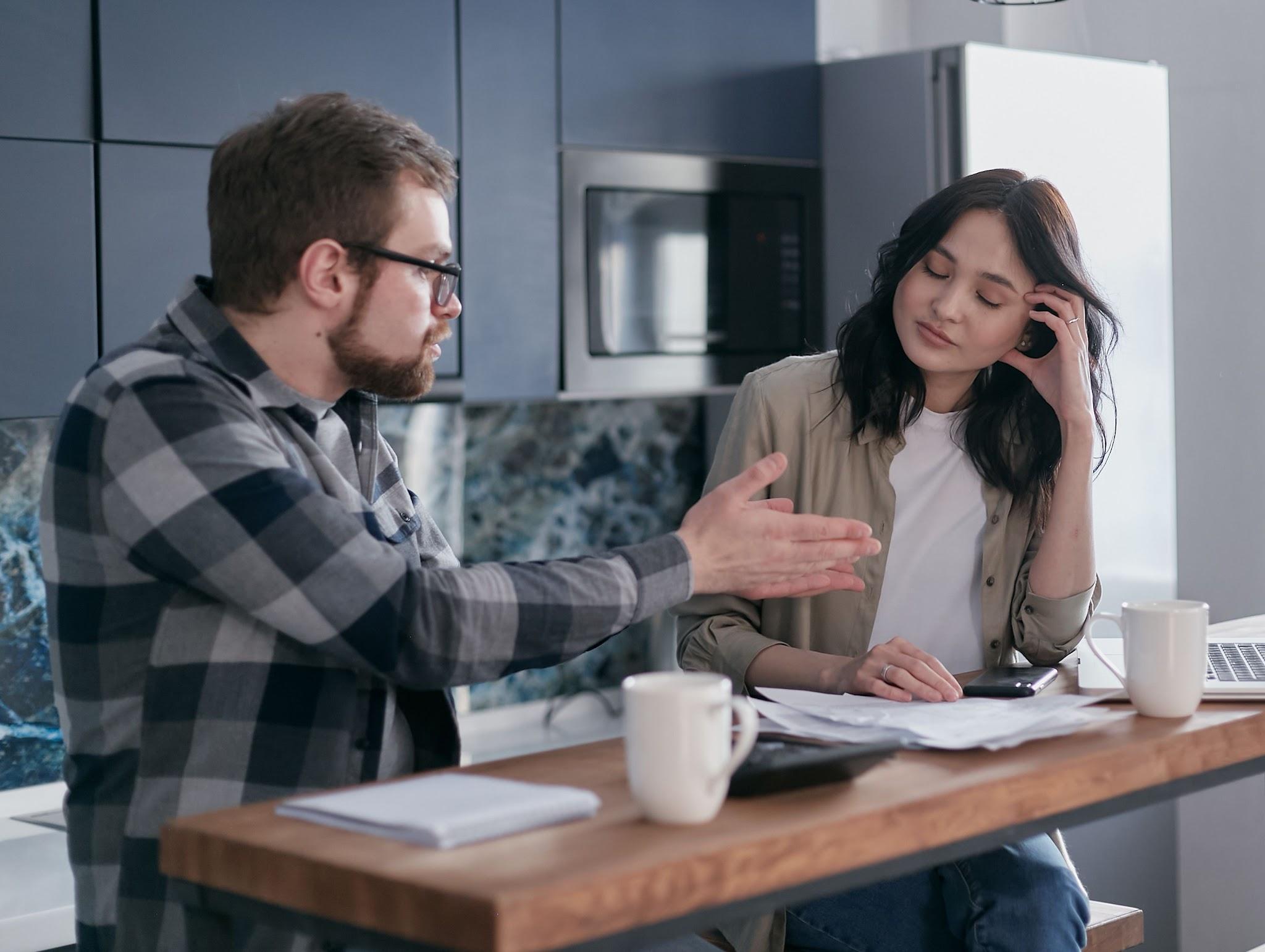 Couple discussing bills at a kitchen table