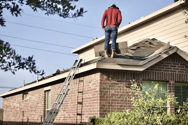 Man inspecting a house roof before winter