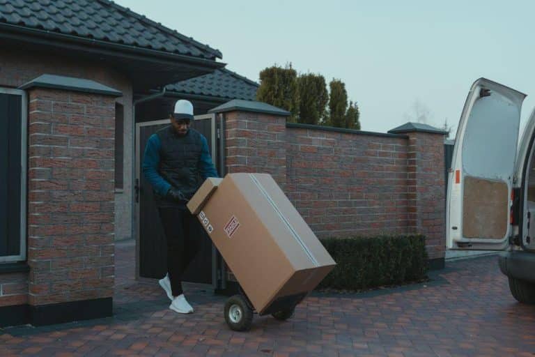 Man unloading a box from a moving van during a