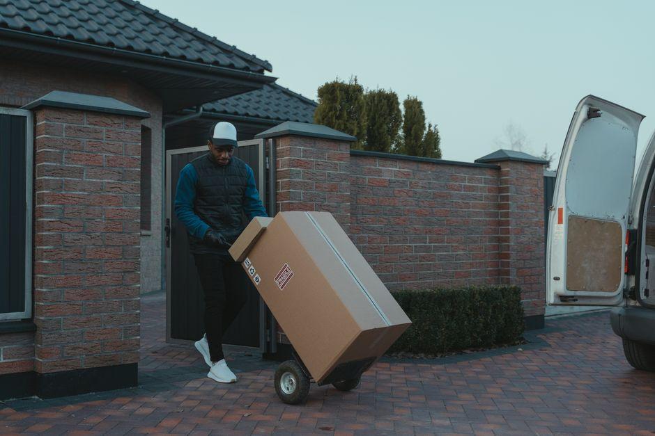 Man unloading a box from a moving van during a
