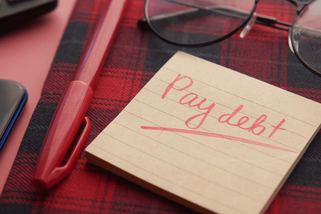 Paper with 'pay debt' written on it next