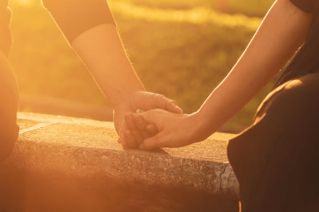 Close up of two people holding hands, symbolizing support