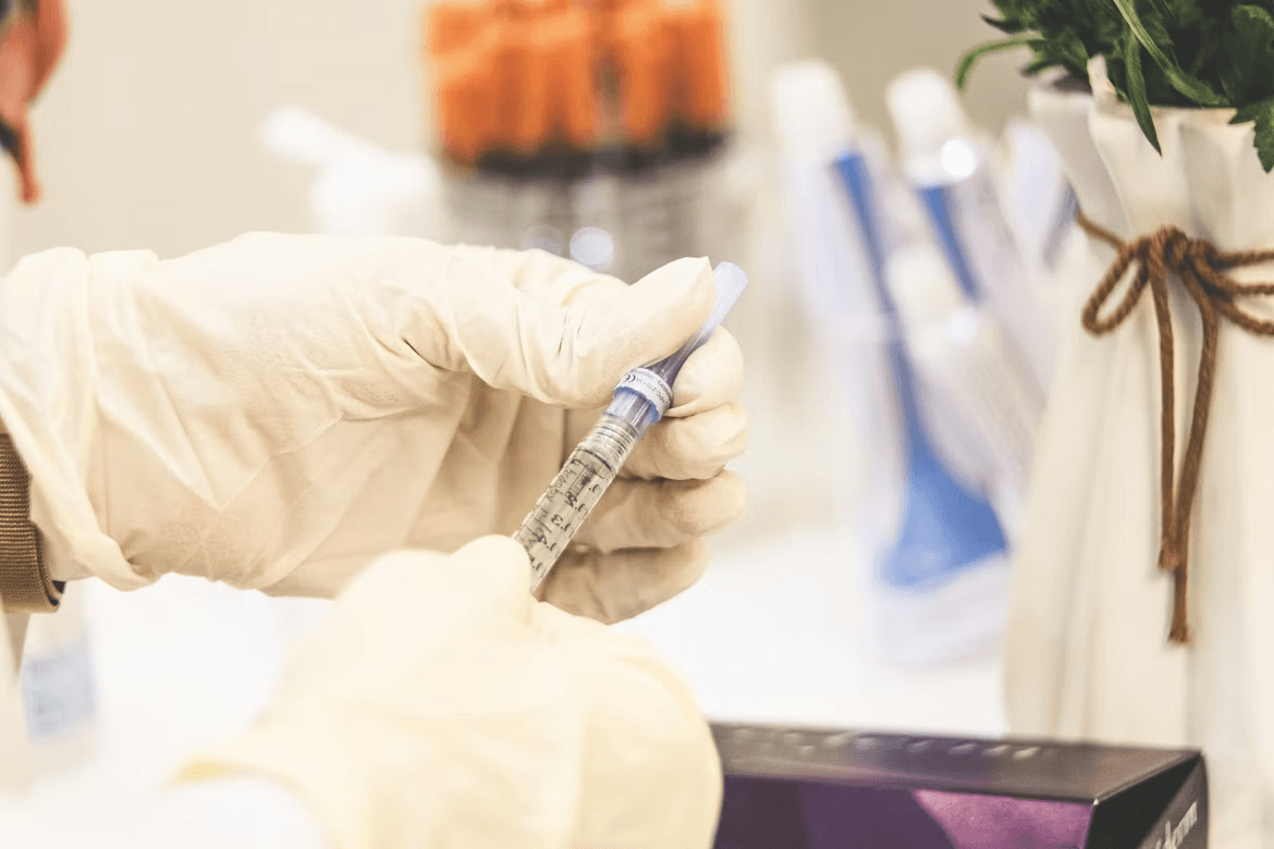 Gloved hand holding a syringe for PRP therapy