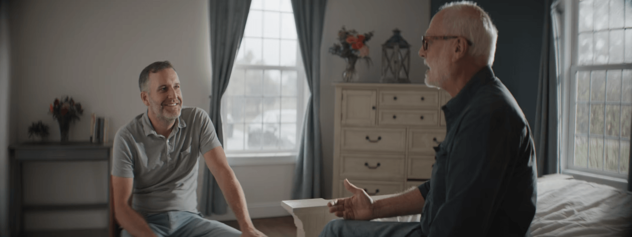 Two men sitting on a bed