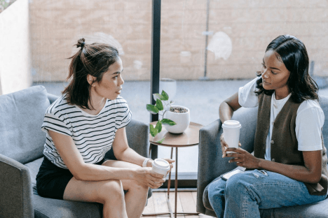 Two women talking on a couch,