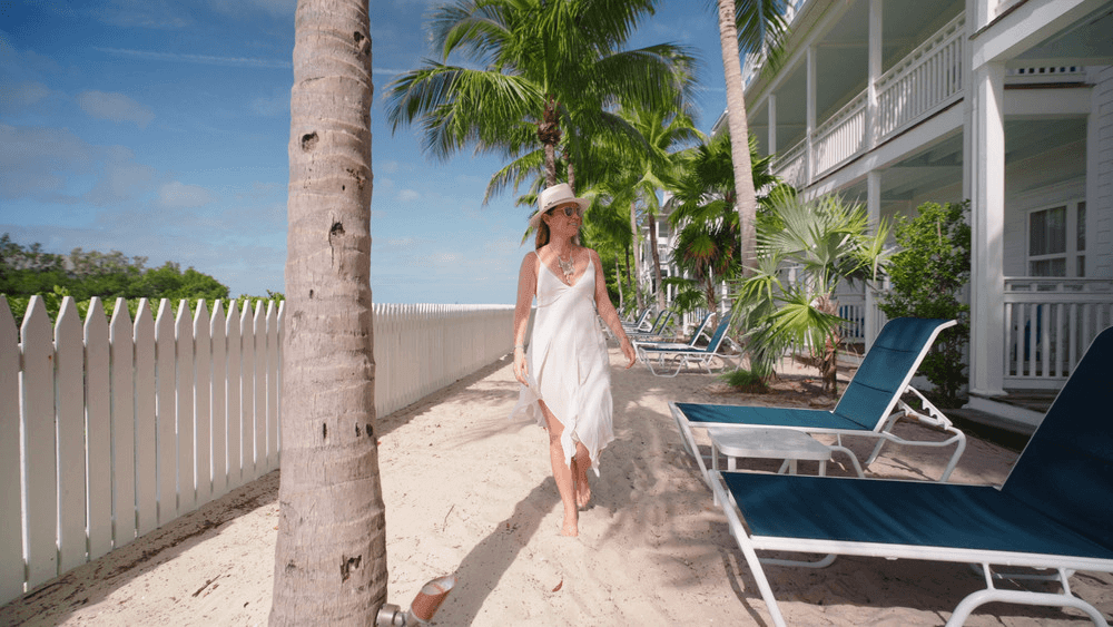 Woman walking on a Florida beach in a white dress