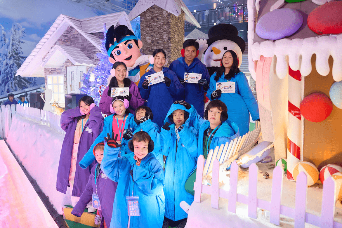 A group of people standing next to a snowman